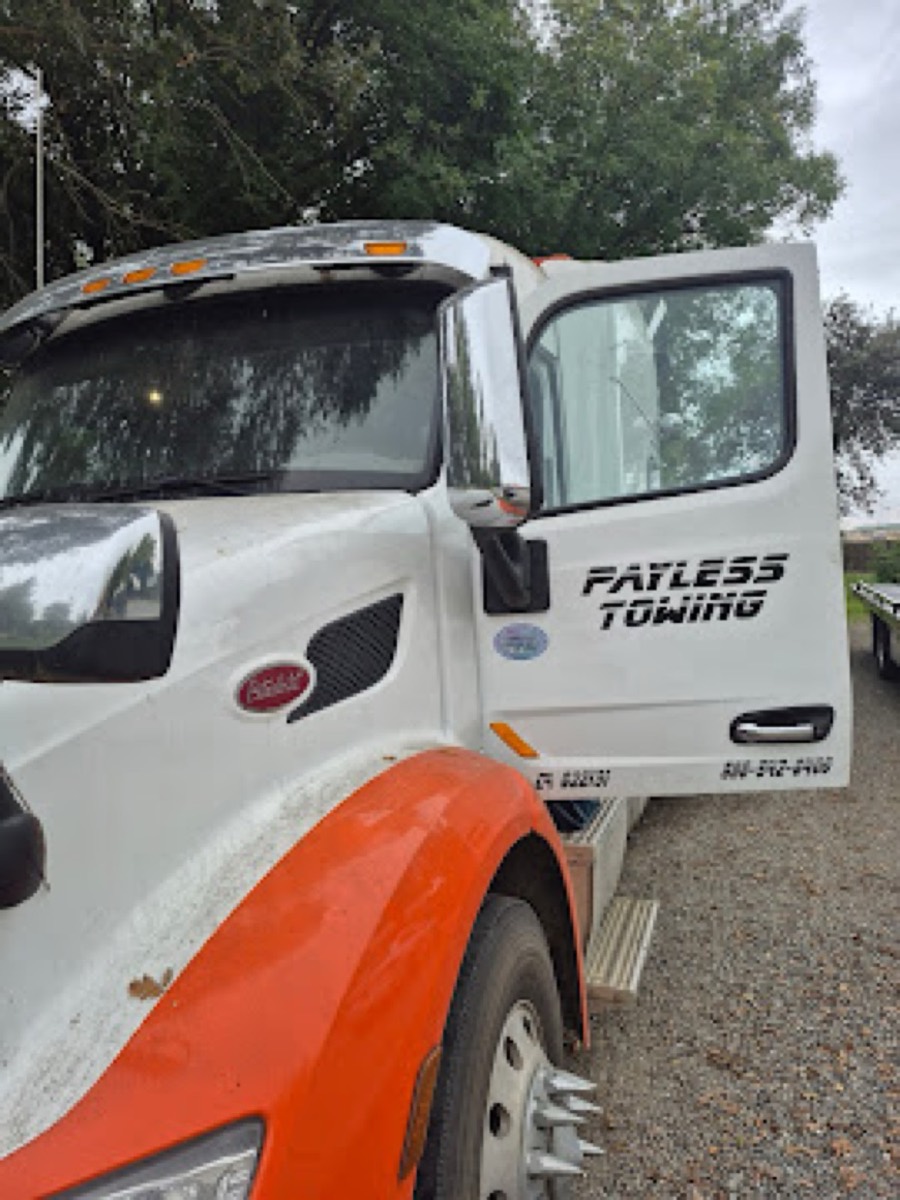 Payless Towing heavy-duty tractor with door open for mobile inspection